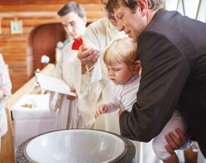 Little baby boy being baptized in catholic church 
