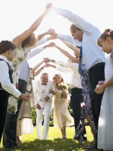 Bride and groom walking under arms of wedding guests