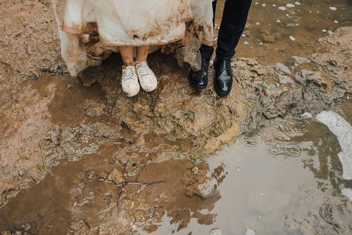 Bride and Groom Standing in a Mud Puddle
