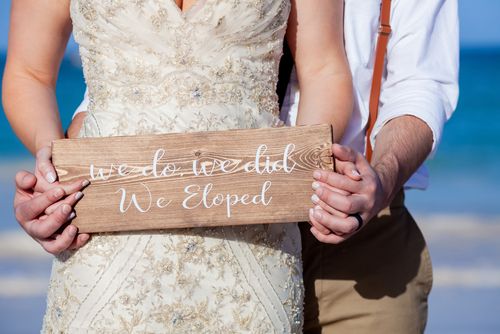 Couple Holding a We Eloped Sign