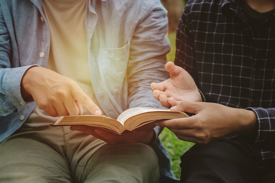 pointing at a holy scripture alongside a companion