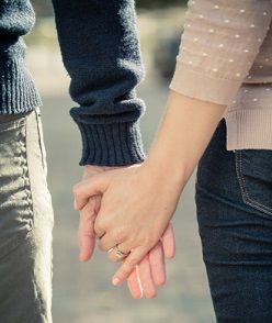 An engaged couple holding hands