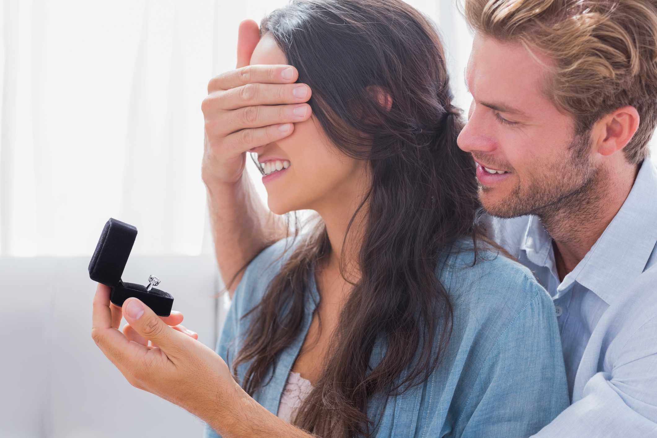 Man hiding his wifes eyes to offer her an engagement ring