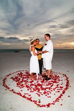 Photo of a wedding officiant performing a ceremony on the beach.
