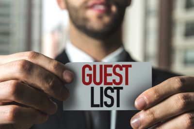 Man Holding a Guest List Sign