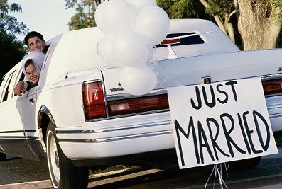 Newlywed couple leaving in a Lincoln