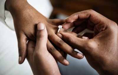Man Placing Engagement Ring on Woman's Hand