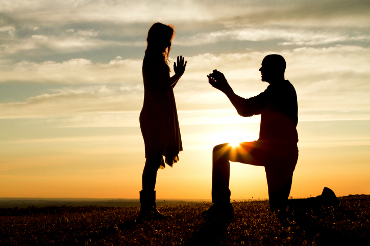 Man proposing to woman at sunset