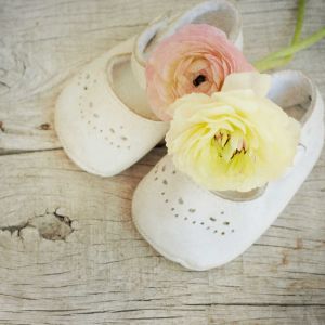 ranunculus flowers bouquet in baby shoes