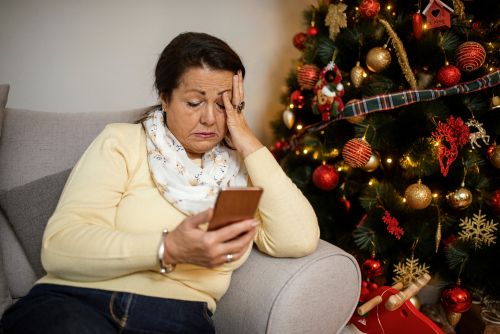 Sad Person Sitting in Front of a Holiday Tree