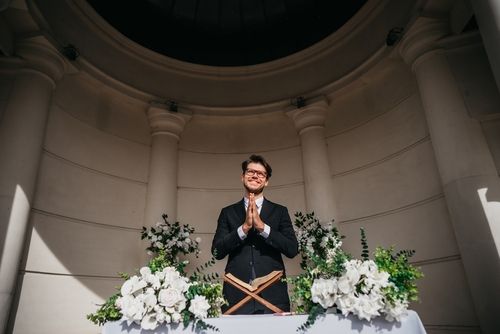 Wedding Officiant Standing at Podium With Flowers