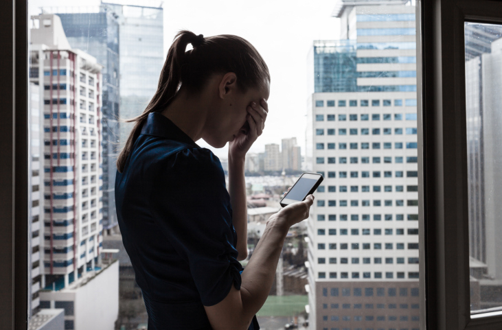 Woman looking at her phone while grieving