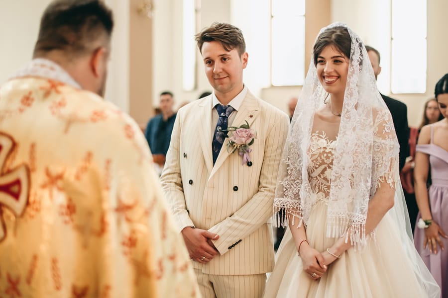 Bride and groom smiling during wedding ceremony at Christian church
