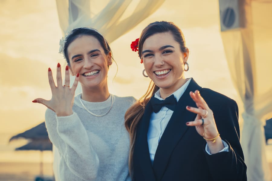 Brides showing wedding rings at gender neutral wedding ceremony