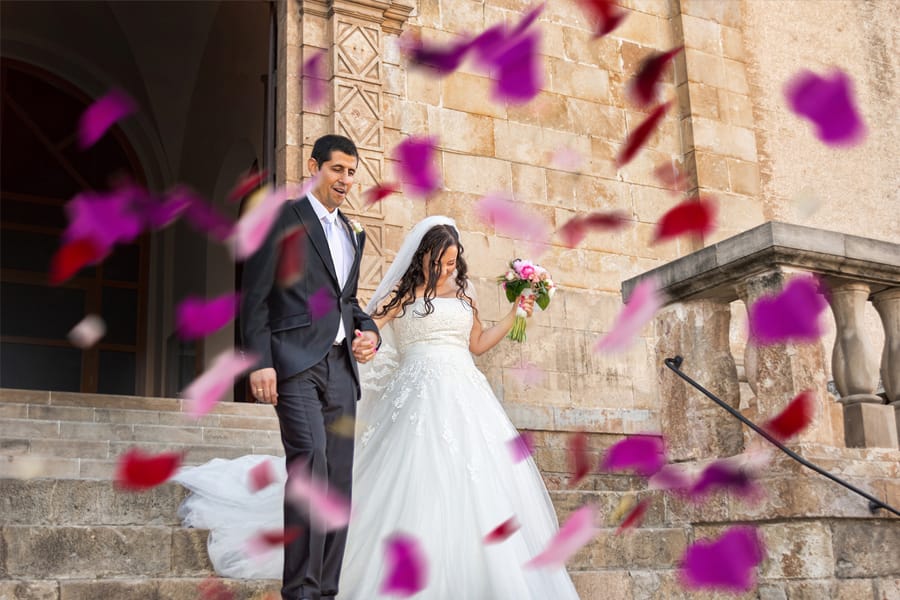 Hispanic couple walking down steps after Spanish wedding