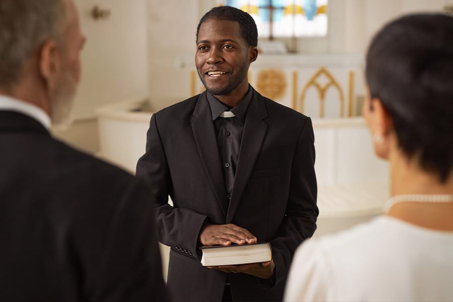 A priest in a church proceeding with the wedding ceremony.