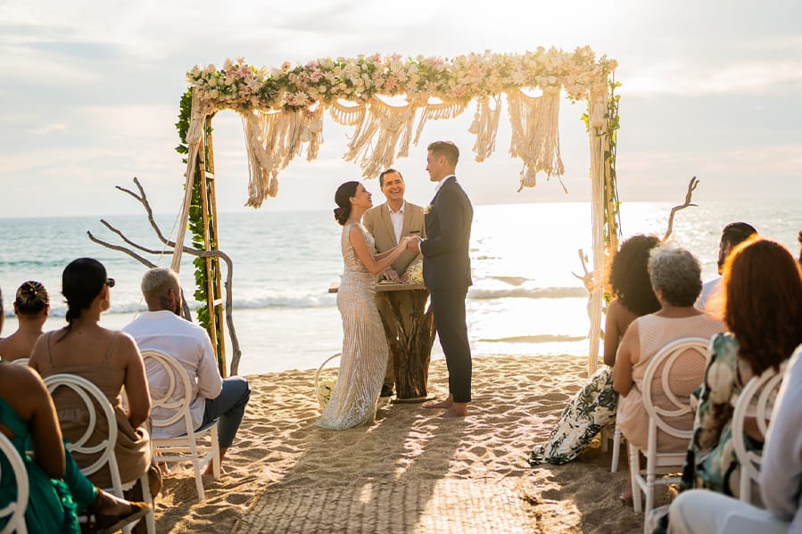Couple exchanging vows on a beach. 
