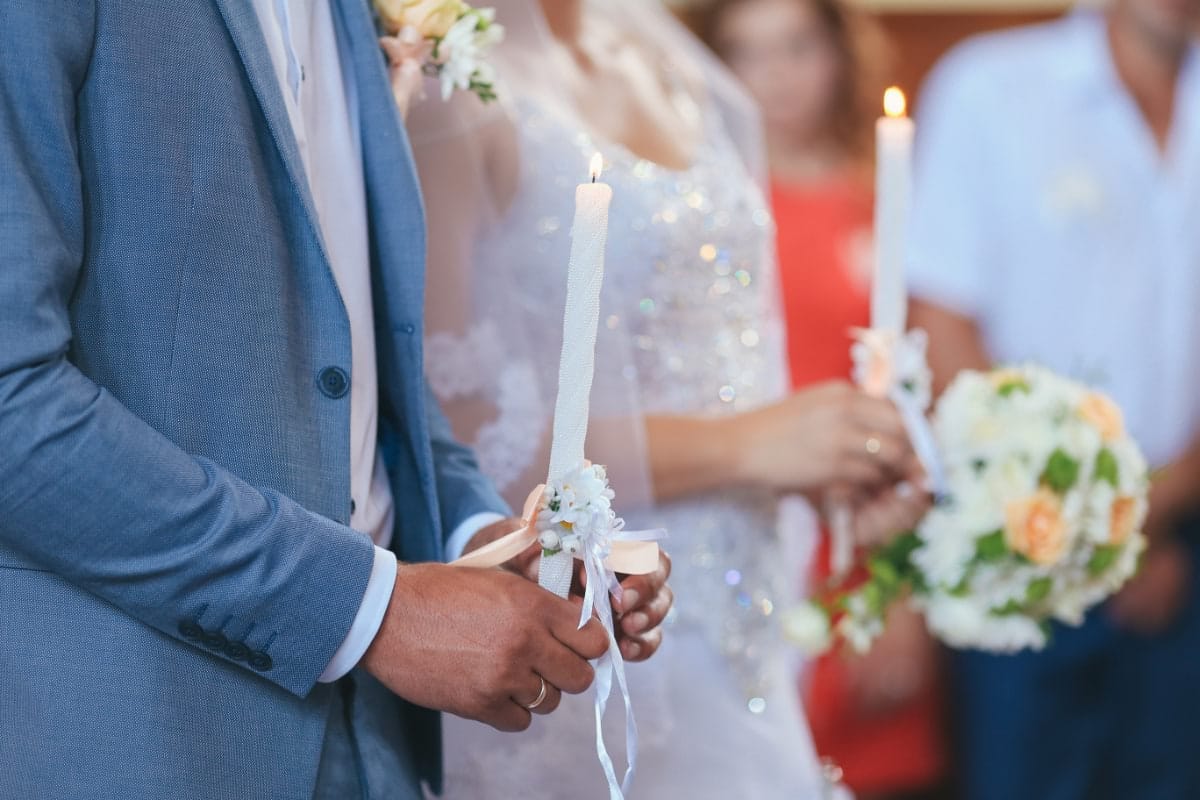 Bride and groom holding unity candles at wedding